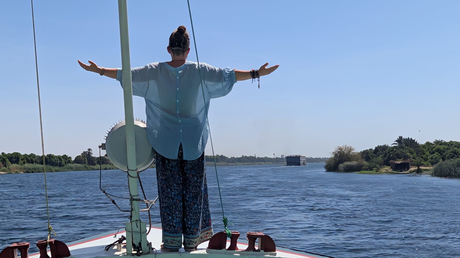 Solo female traveller standing on a boat on the Nile in Egypt.